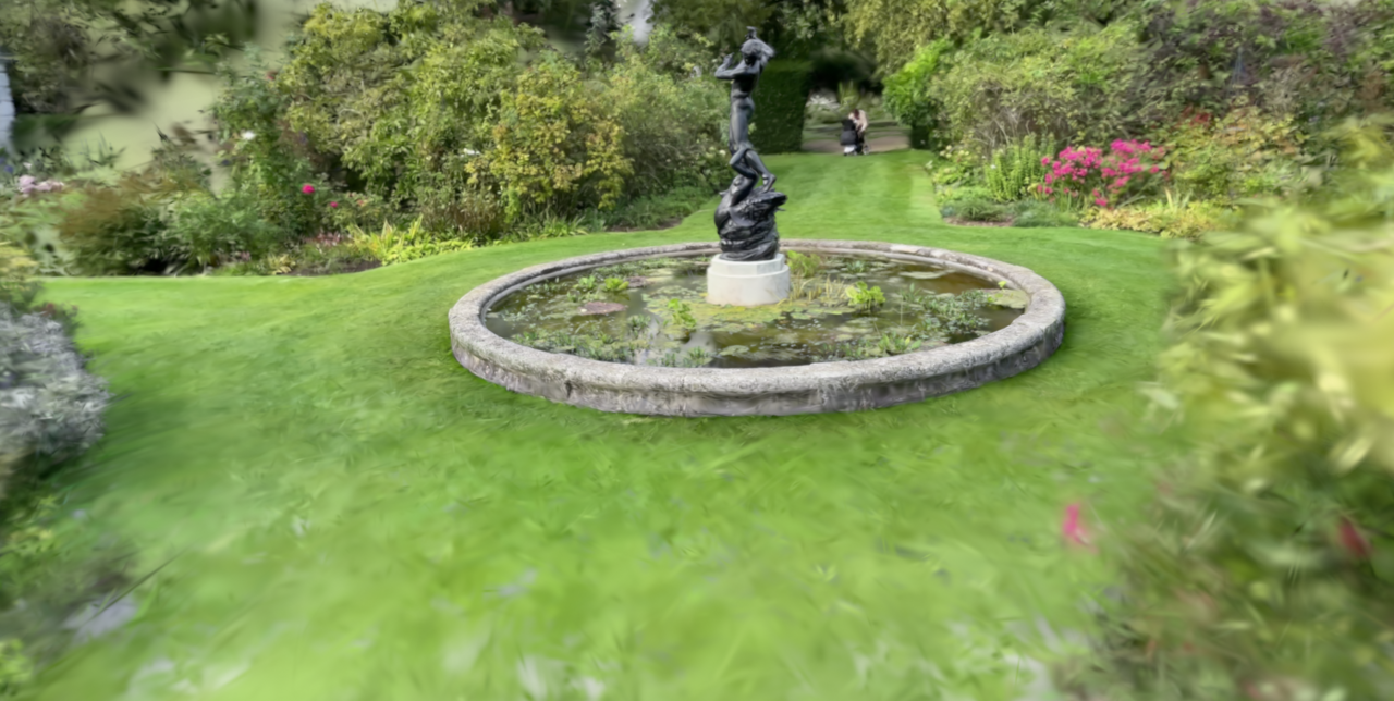 A garden fountain reconstructed by Gaussian splatting, photorealistic at the center with soft smeared geometry at the edges